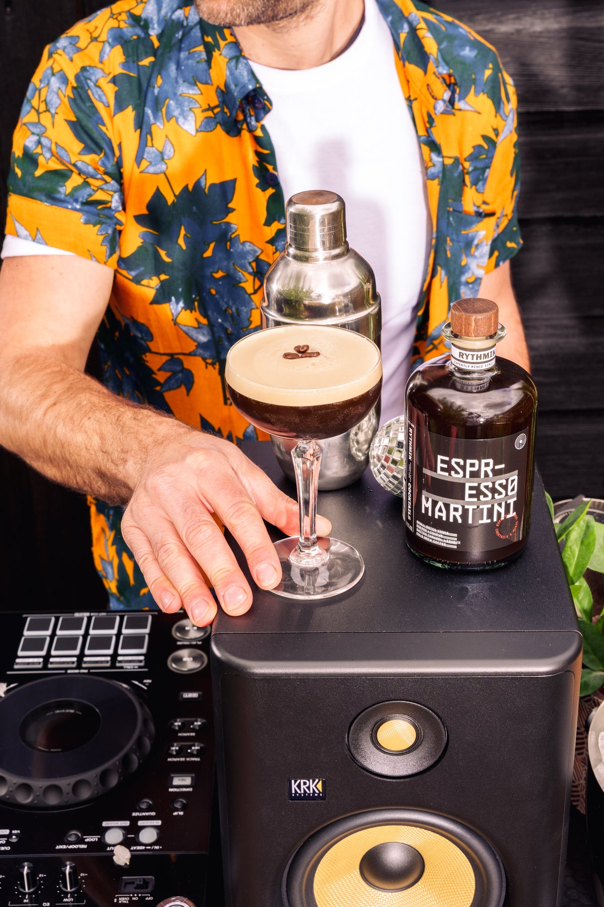 Cocktail preparation with martini glass and espresso martini liqueur bottle in foreground