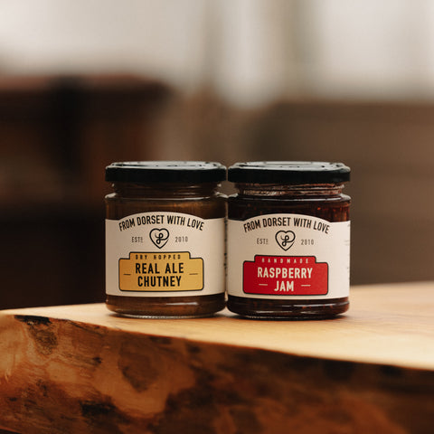Two jars of jam on a wooden surface with a blurred background