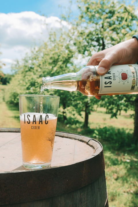 Isaac Cider being poured into a branded glass in the family orchard.
