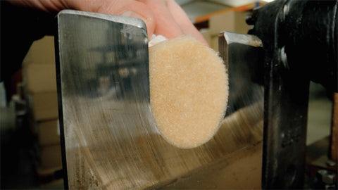 A close view of pale bristles positioned at a factory machine
