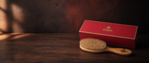 Kent Brushes satinwood hairbrush and red presentation box in an art-directed studio still life